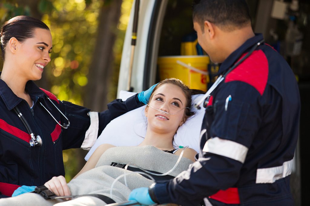 Patient lying on a trolley with two paramedics
